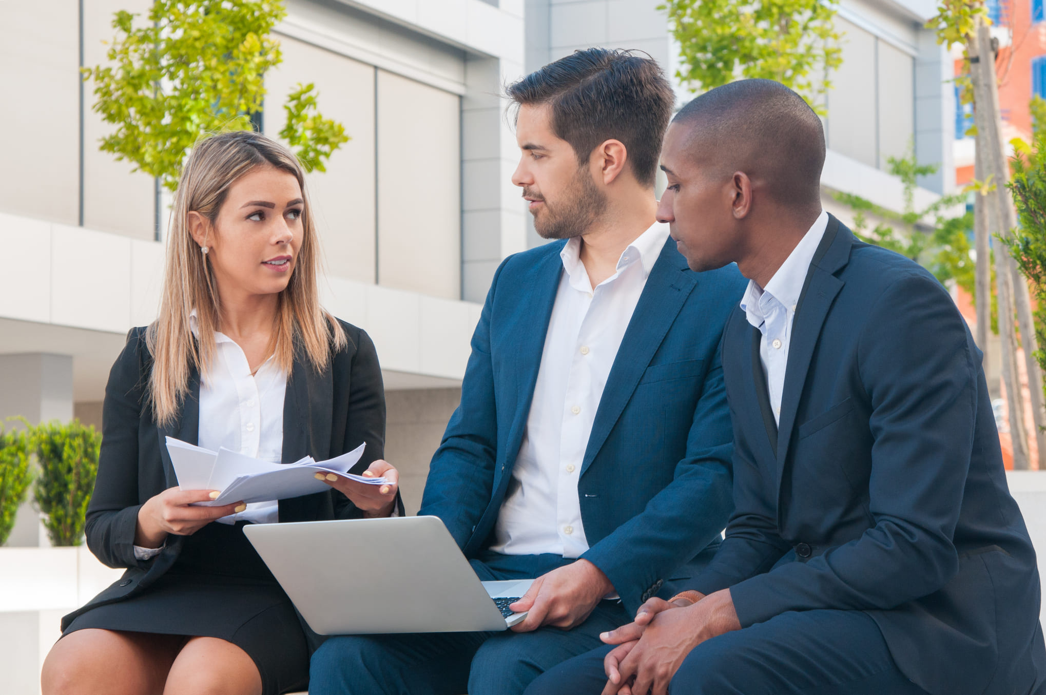 two men talking to a woman 