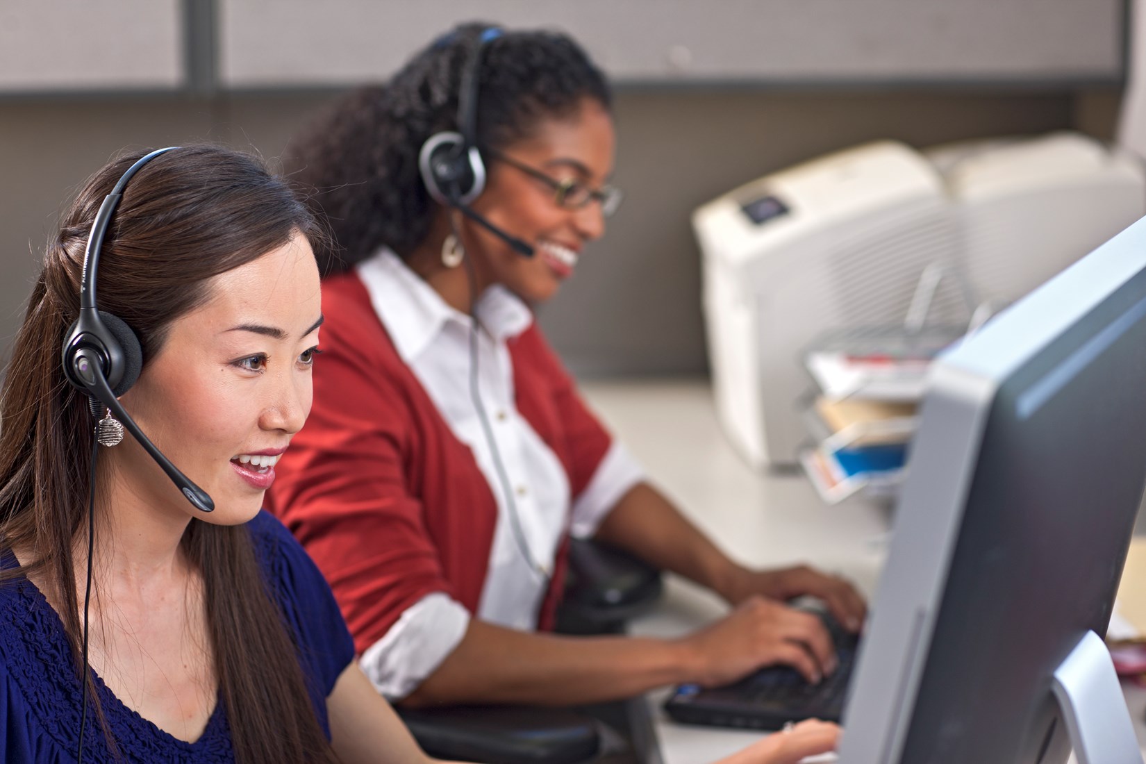 two women sitting at computer